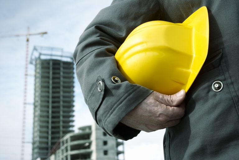 worker getting ready to wear helmet